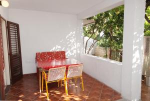 uma mesa e cadeiras num alpendre com uma janela em Apartments with a parking space Stari Grad, Hvar - 5724 em Stari Grad