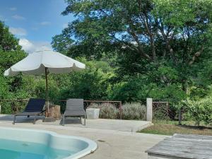 ein Sonnenschirm und zwei Stühle neben einem Whirlpool in der Unterkunft Casa de Huéspedes La Aguada in Salta