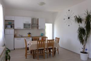 a kitchen and dining room with a table and chairs at Family friendly seaside apartments Sumartin, Brac - 5771 in Sumartin