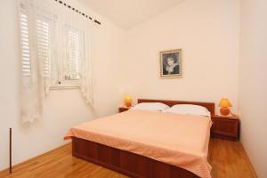 a white bedroom with a bed and a window at Apartments by the sea Sucuraj, Hvar - 5680 in Sućuraj