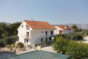 una casa con una pista de tenis delante en Apartments by the sea Stari Grad, Hvar - 5697, en Stari Grad