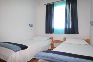 twee bedden in een kamer met een raam bij Apartments by the sea Vinjerac, Zadar - 5824 in Vinjerac