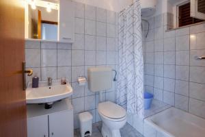 a white bathroom with a toilet and a sink at Family friendly seaside apartments Kozino, Zadar - 5756 in Petrcane