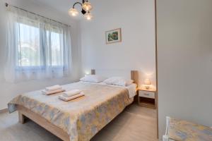 a bedroom with a bed with two towels on it at Family friendly seaside apartments Kozino, Zadar - 5756 in Petrcane