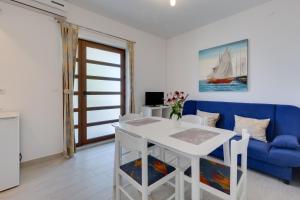 a living room with a white table and a blue couch at Family friendly seaside apartments Kozino, Zadar - 5756 in Petrcane +29 photos