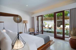 a bedroom with a bed and a view of a pool at Villa Sakura. Luxury 3 Bedroom Villa. in Selong Belanak +35 photos