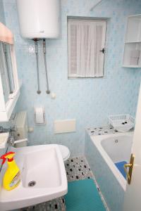 沃迪采的住宿－Apartments with a parking space Vodice - 5890，浴室配有白色水槽和浴缸。