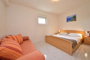 um quarto com uma cama e um sofá em Family friendly apartments with a swimming pool Drage, Biograd - 5904 em Drage