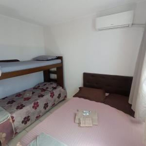 a bedroom with a bed and a bunk bed with a pillow at Apto Agua Marinha in Campos dos Goytacazes