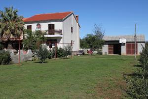 uma casa com um cesto de basquetebol no quintal em Apartments for families with children Privlaka, Zadar - 5747 em Privlaka
