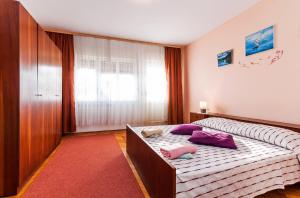 um quarto com uma cama com almofadas roxas em Apartments for families with children Privlaka, Zadar - 5747 em Privlaka
