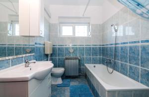 uma casa de banho com uma banheira, um lavatório e um WC. em Apartments for families with children Privlaka, Zadar - 5747 em Privlaka