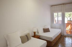 sala de estar con 2 camas y ventana en Casa adosada en Pals Playa by Apartaments Golf, en Pals