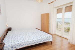 1 dormitorio con cama y ventana grande en Apartments by the sea Vrsi - Mulo, Zadar - 5790, en Vrsi