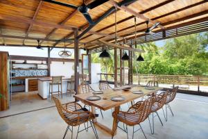 a large wooden table and chairs on a patio at Villa Sakura. Luxury 3 Bedroom Villa. in Selong Belanak