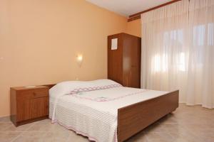 um pequeno quarto com uma cama e um armário de madeira em Apartments with a parking space Stari Grad, Hvar - 5730 em Stari Grad