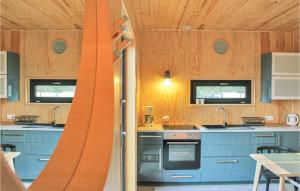 a kitchen with wooden walls and blue cabinets at Gorgeous Home In Nowe Warpno With Wifi in Nowe Warpno