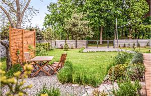a garden with a table and chairs in the grass at Gorgeous Home In Nowe Warpno With Wifi in Nowe Warpno +15 photos