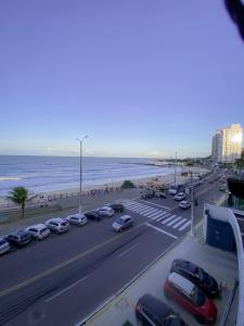 a parking lot with cars parked next to the beach at Acomodação aconchegante à beira- mar in Natal