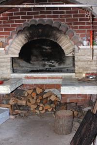 un four en brique avec un tas de bois de chauffage dans l'établissement Studio Bibinje 5741a, à Bibinje