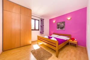 een slaapkamer met een paarse muur en een bed bij Apartments with a parking space Nin, Zadar - 5857 in Nin