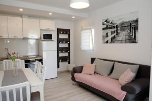 een woonkamer en een keuken met een bank en een tafel bij Apartments by the sea Kozino, Zadar - 5803 in Kožino