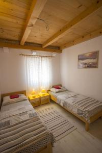 2 łóżka w pokoju z drewnianym sufitem w obiekcie Seaside secluded apartments Cove Skozanje, Hvar - 5713 w mieście Gdinj