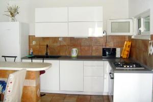 a kitchen with white cabinets and a counter top at Apartments by the sea Mudri Dolac, Hvar - 5694 in Vrboska