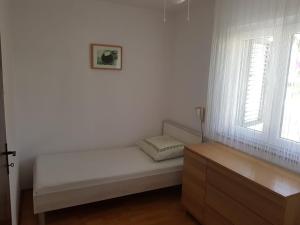 Cama blanca en habitación con ventana en Apartments by the sea Basina, Hvar - 5700, en Vrboska