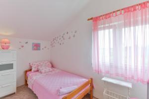 a small bedroom with a bed and a window at Apartments with a parking space Rtina - Stosici, Zadar - 5881 in Ražanac