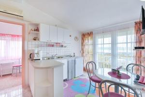 a kitchen and dining room with a table and chairs at Apartments with a parking space Rtina - Stosici, Zadar - 5881 in Ražanac