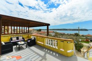 a roof deck with furniture and a view of the water at Apartments with a parking space Rtina - Stosici, Zadar - 5881 in Ražanac