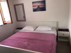 sypialnia z dużym łóżkiem i fioletowym kocem w obiekcie Seaside secluded apartments Cove Pobij, Hvar - 5712 w mieście Gdinj