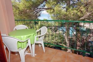 a balcony with a table and chairs and the ocean at Seaside secluded apartments Cove Tatinja, Hvar - 5729 in Vrbanj