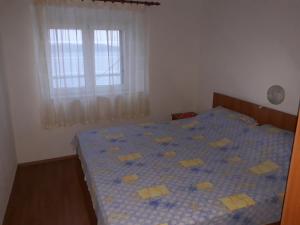 ein Schlafzimmer mit einem blauen Bett mit gelben Quadraten darauf in der Unterkunft Holiday house with a parking space Zavala, Hvar - 5702 in Zavala