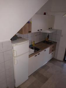 eine kleine Küche mit weißen Schränken und einem Waschbecken in der Unterkunft Holiday house with a parking space Zavala, Hvar - 5702 in Zavala