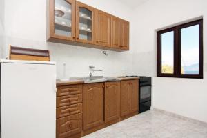 a kitchen with wooden cabinets and a sink at Apartments by the sea Cove Bristova, Hvar - 5716 in Bogomolje