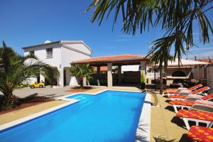 a swimming pool with lounge chairs and a house at Apartments and rooms with a swimming pool Sukosan, Zadar - 5906 in Sukošan