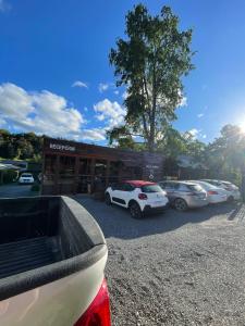 uma fila de carros estacionados em frente a um concessionário em Treca Rupan Lodge em Neltume