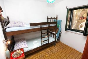 een slaapkamer met een stapelbed in een kamer met een raam bij Seaside secluded apartments Cove Zavala - Gdinj, Hvar - 5717 in Bogomolje