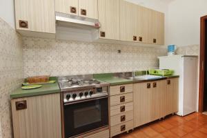 a kitchen with a stove and a refrigerator at Apartments with a parking space Supetar, Brac - 5676 in Supetar