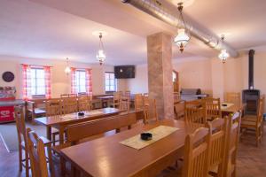 ヴィシュシー・ブロトにあるUbytovna Pod Hrázíの木製のテーブルと椅子が備わる空きレストランです。