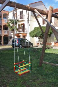 a swing in a yard next to a building at Apartment Biograd na Moru 5899c in Biograd na Moru
