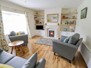 a living room with couches and a fire place at 2 Castle Cove in Drumahayre