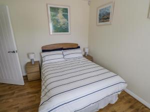 a bedroom with a bed with a striped blanket at 2 Castle Cove in Drumahayre