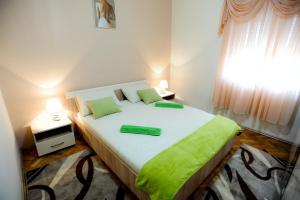 - une chambre avec un grand lit et 2 oreillers verts dans l'établissement Apartments with a parking space Sukosan, Zadar - 5897, à Sukošan