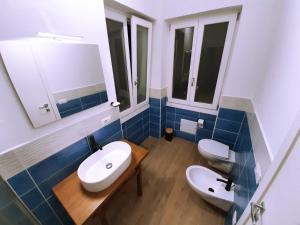 a bathroom with two sinks and two mirrors at Camera Olbia Centro, vacanze Olbia e dintorni- Blue House Guest House in Olbia