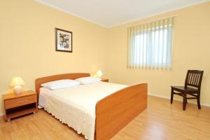 1 dormitorio con 1 cama y 1 silla en Seaside holiday house Zaton, Zadar - 5910, en Zaton