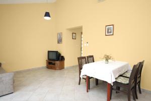 comedor con mesa, sillas y TV en Seaside holiday house Zaton, Zadar - 5910, en Zaton