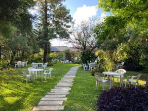 une rangée de tables et de chaises sur une pelouse dans l'établissement TOLHUIN COLON, à Colón